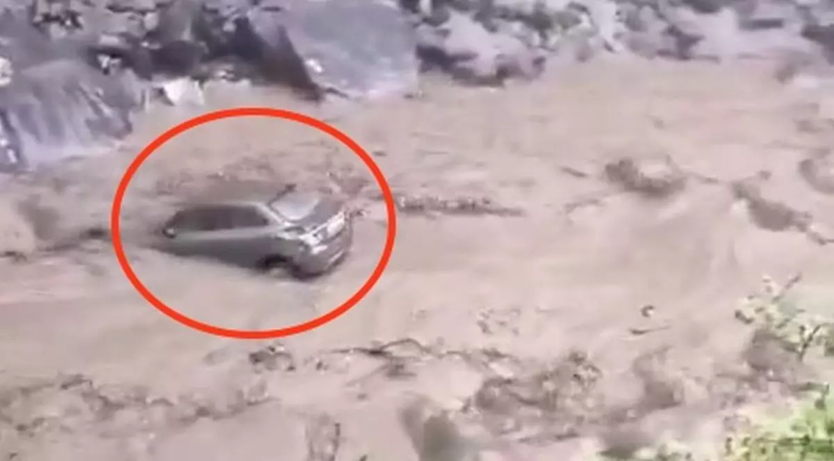 O mașină a fost luată de ape, iar sătenii încearcă să scape de râurile de noroi, după ce o viitură fulgerătoare le-a luat casele în urma unor inundații din Dharali, India, 6 august 2025