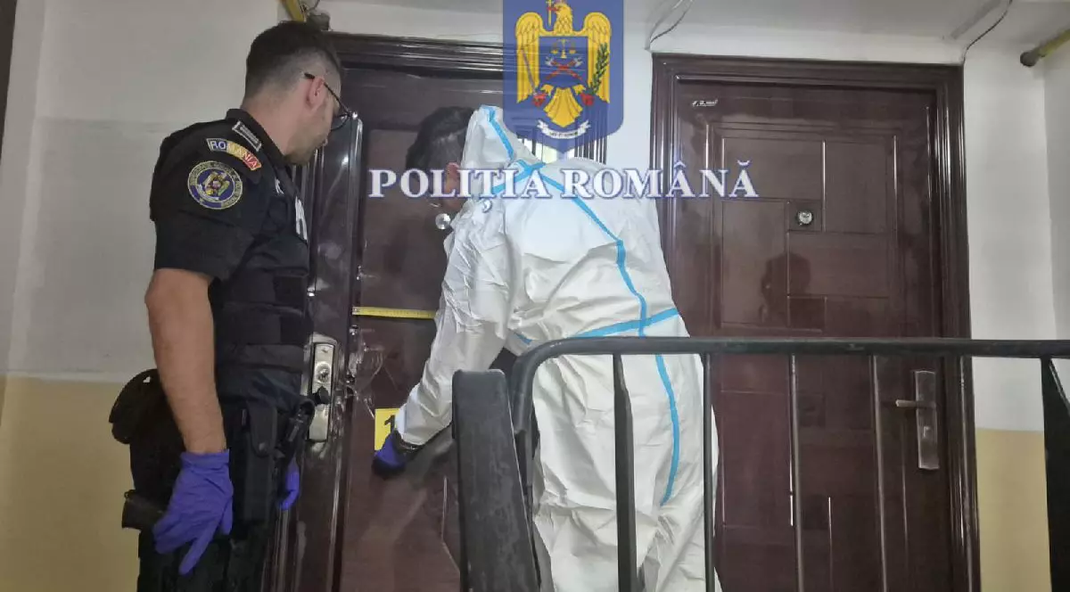 Un criminalist și un polițist în timp ce blochează accesul spre locul crimei