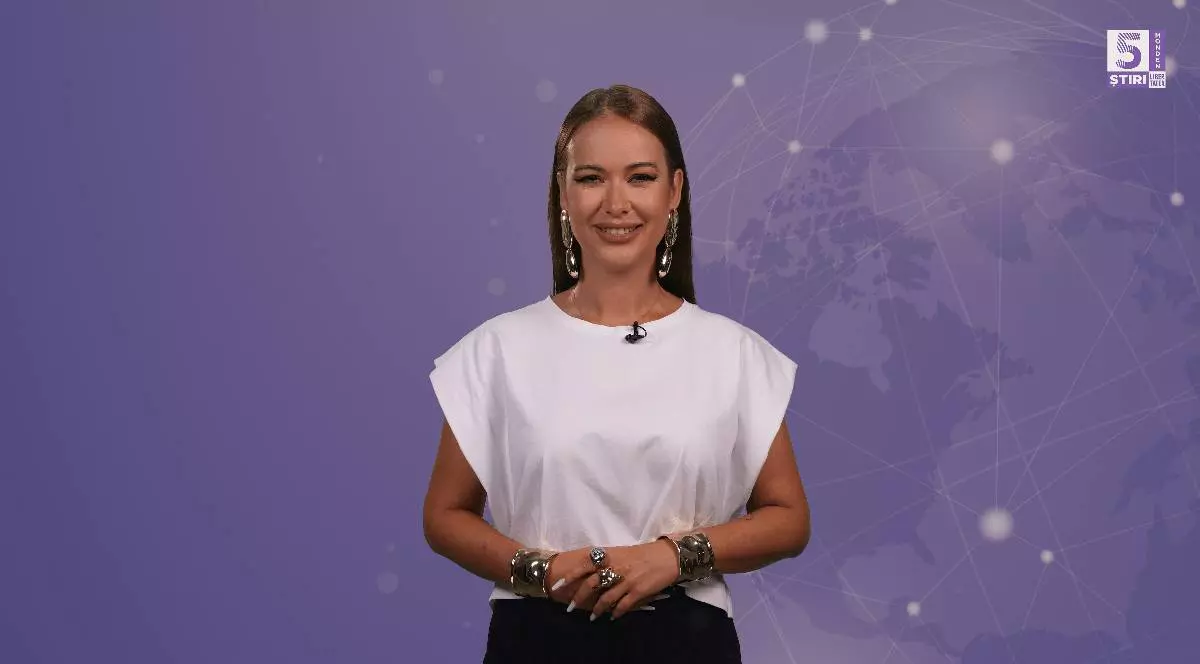 Denisa Macovei prezintă rubrica 5 știri by Libertatea - Monden- îmbărcată într-un tricou alb, pe fundalul violet al emisiunii