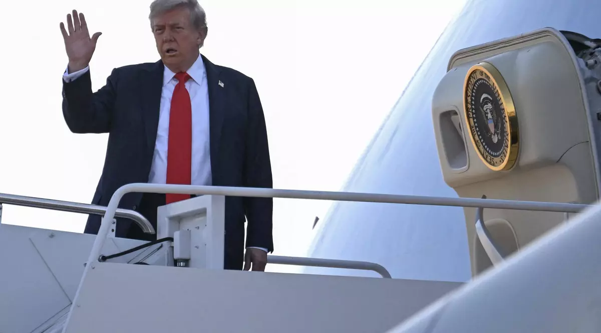 Donald Trump salută de pe scara Air Force One, care îl duce în Alaska. Foto Profimedia