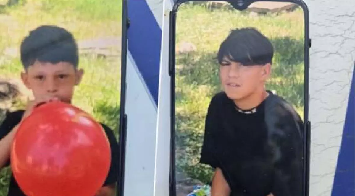 Doi copii, unul mai mic suflă într-un balon roșu, iar cel mai mare se află în natură