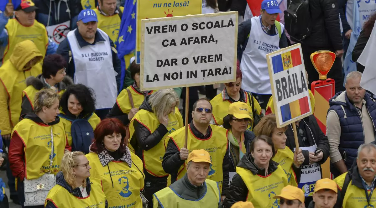 Un barbat afiseaza o pancarta in timpul unui mars de protest organizat de sindicatele din Invatamant intre Piata Victoriei si Palatul Parlamentului, prin care cer cresteri salariale, in Bucuresti, miercuri, 10 mai 2023.