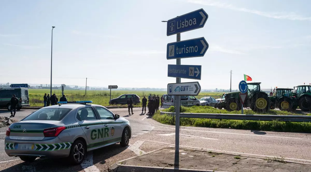O mașină a poliției portugheze este parcată în apropierea unei autostrade blocate de fermieri, în apropierea graniței cu Spania, februarie 2024