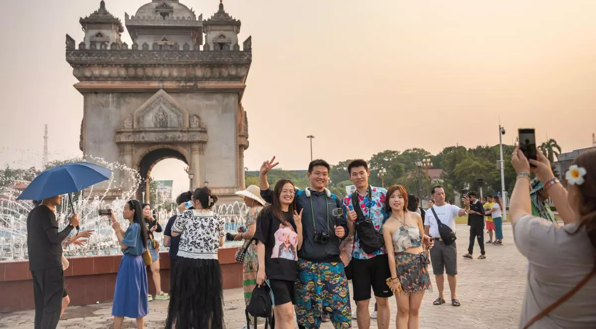 Mai mulți turiști se pozează în fața monumentului Patuxay din Vientiane, Laos, 1 mai 2024