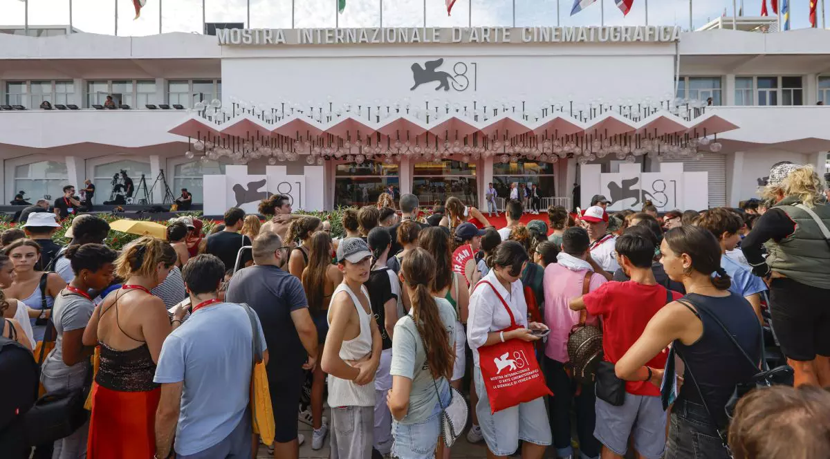 Numeroși oameni stau și așteaptă proiecția unui film în cadrul celei de-a 81-a ediții a Festivalului Internațional de Film de la Veneția, pe 4 septembrie 2024