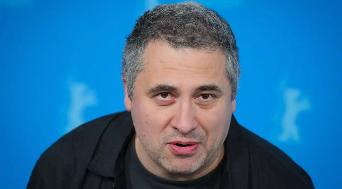 Radu Jude îmbrăcat într-o cămașă neagră vorbește în timpul unuei conferințe de presă de la Berlin International Film, februarie 2025