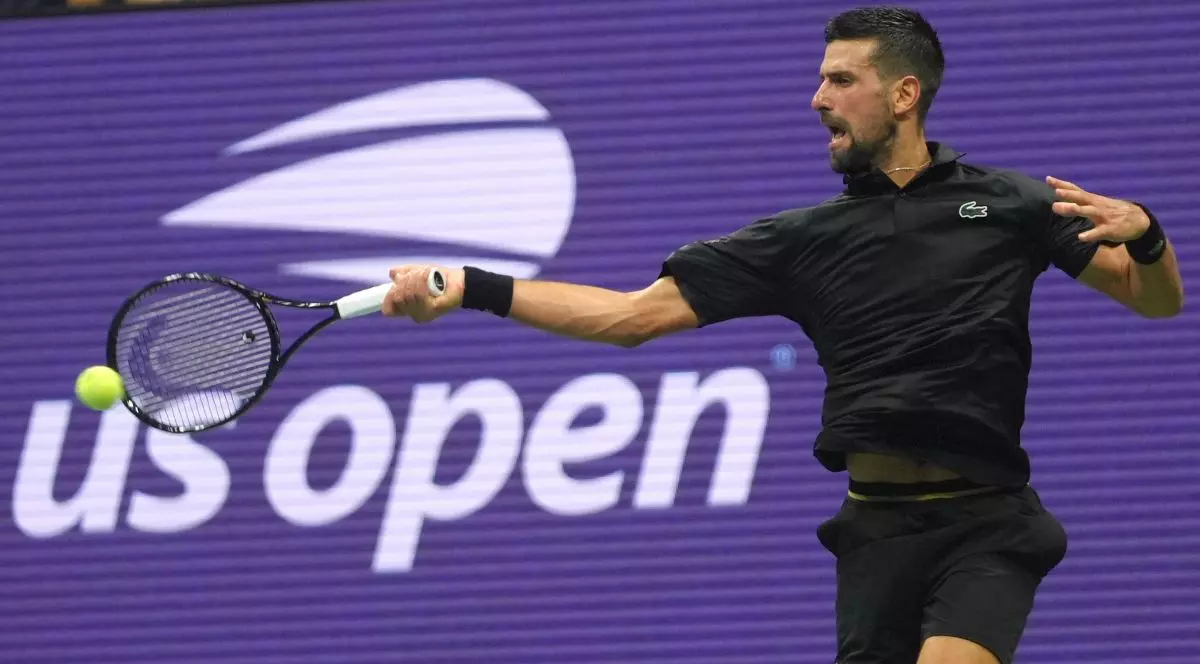 Novak Djokovic, îmbrăcat în negru, surprins returnând o minge în timpul unui meci la US Open, august 2025