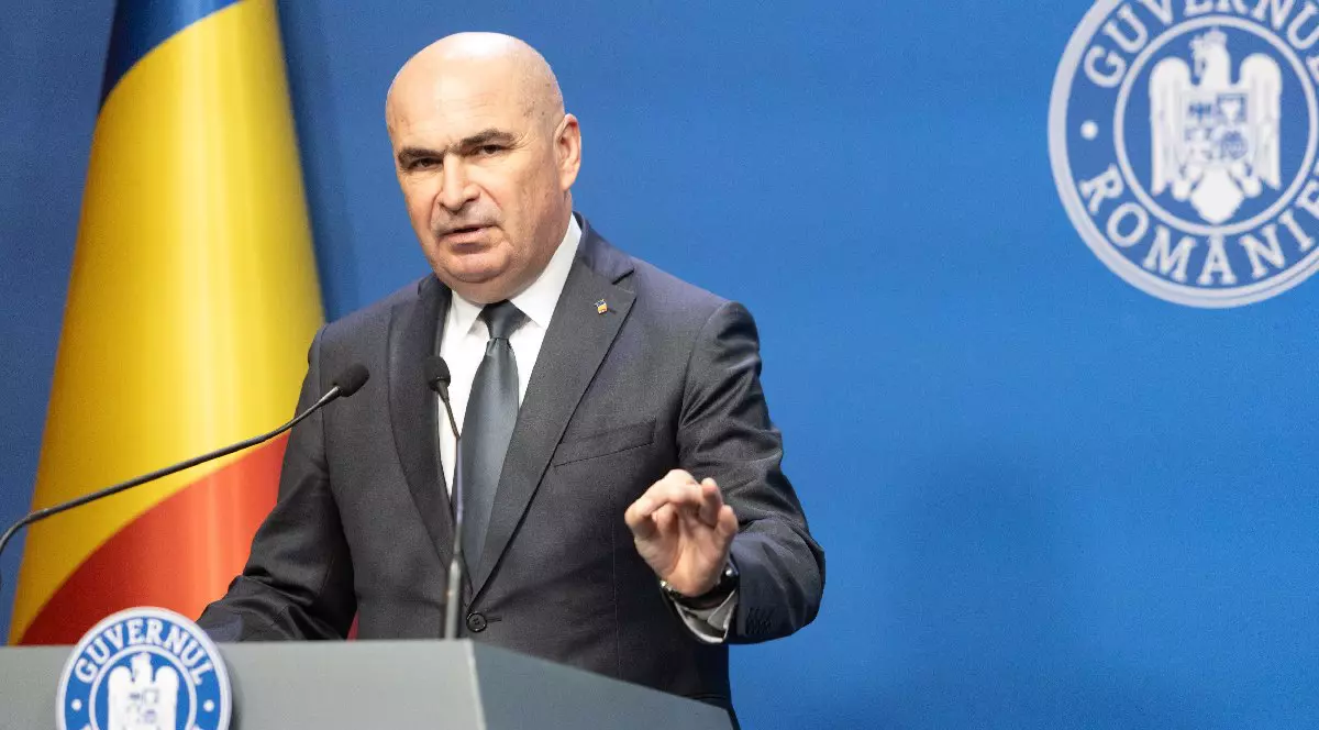 Premierul Ilie Bolojan sustine o conferinta de presa in cadrul careia prezinta pachetul de masuri privind reforma administraţiei publice locale,vineri, 18 iulie 2025, in Bucuresti. In stânga se vede steagul României