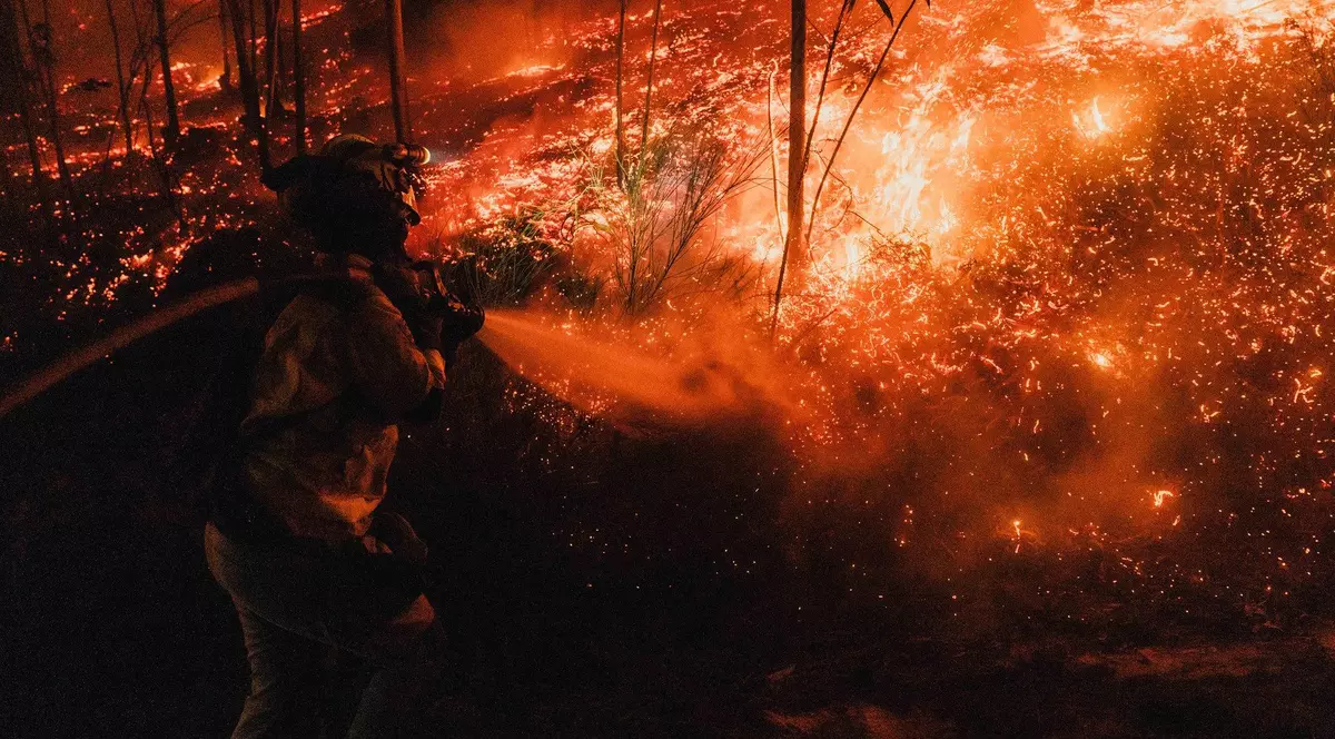 Imagine cu un pompier care încearcă să stingă un incendiu de vegetație din Galicia, Spania