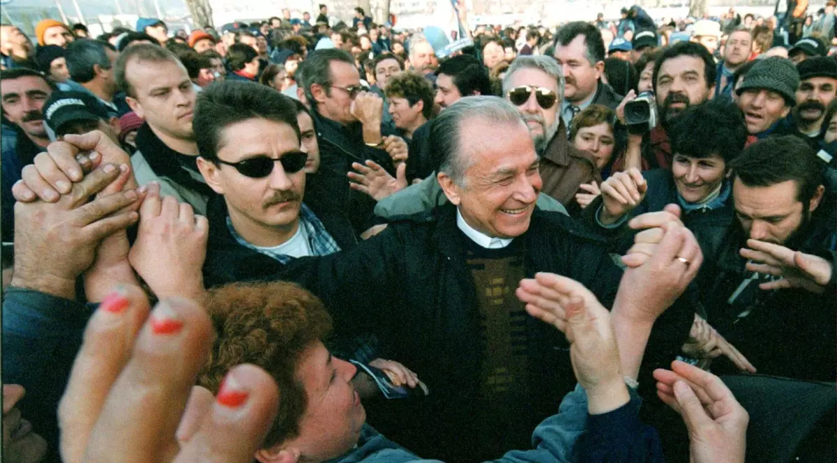 Ion Iliescu, in pulover si sacou, in mijlocul oamneilor