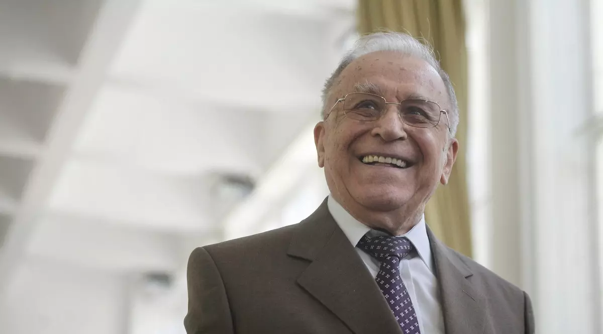 Ion Iliescu surprins zâmbind. Fostul președinte poartă un sacou de culoare maro, o cămașă albă și cravată