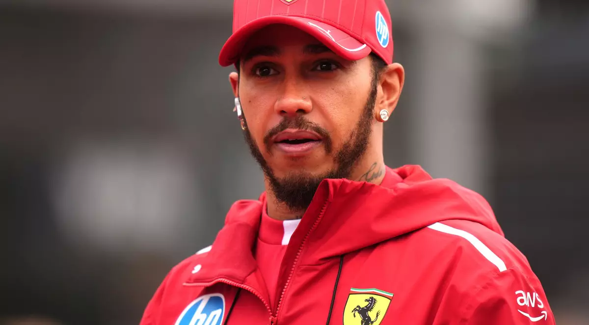 Imagine cu Lewis Hamilton purtând o șapcă roșie cu logo-ul Ferrari și o bluză de aceeași culoare