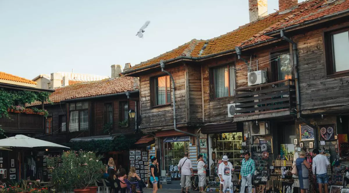 Mai multe magazine din bazarul din Nessebar Old Town, oamenii se uită la tarabe și cumpără magneți de frigider