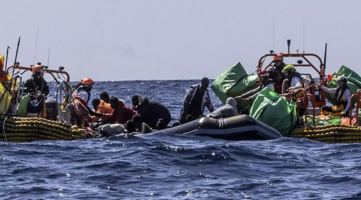 doua bărci pe mare incearca sa salveze persoare cazute in apă