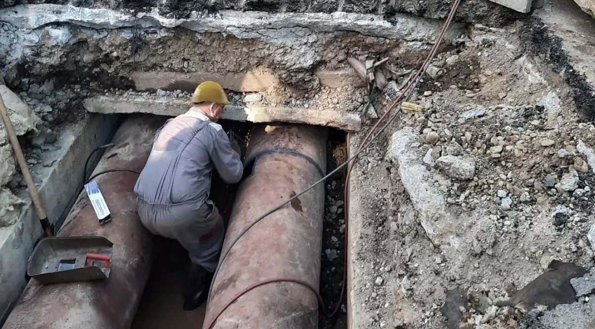 Muncitor al Termoenergetica București în timp ce lucrează la o țeavă, în șantier