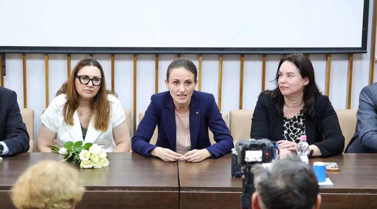 Oana Țoiu, ministrul Afacerilor Externe, în timpul unei conferințe de presă susținute în Ucraina, aceasta stă la masă și vorbește în fața jurnaliștilor