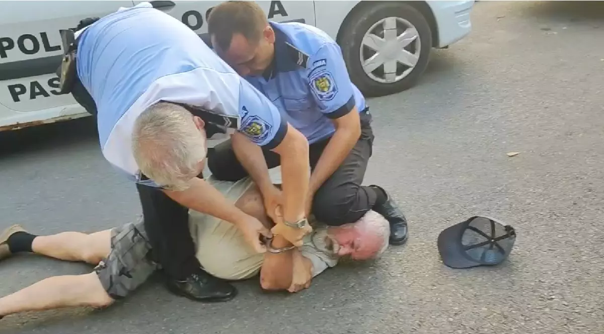 Un pensionar incatușat, pus la pământ de doi polițiști locali