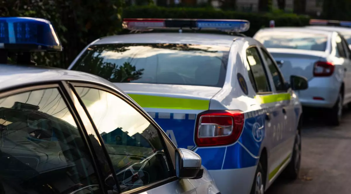 Mașină de Poliție, parcată între alte mașini pe stradă