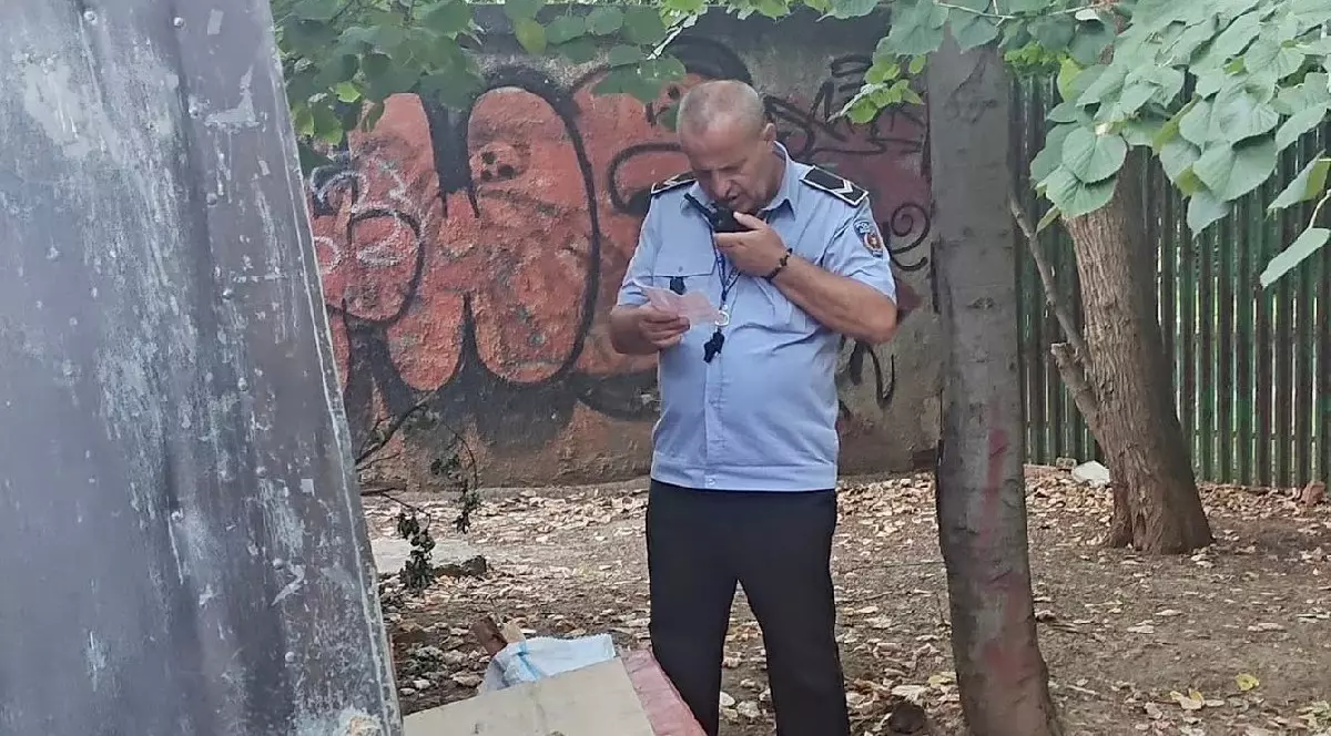 Un polițist vorbește prin stație, tine în mână un document - Bucuresti, august 2025