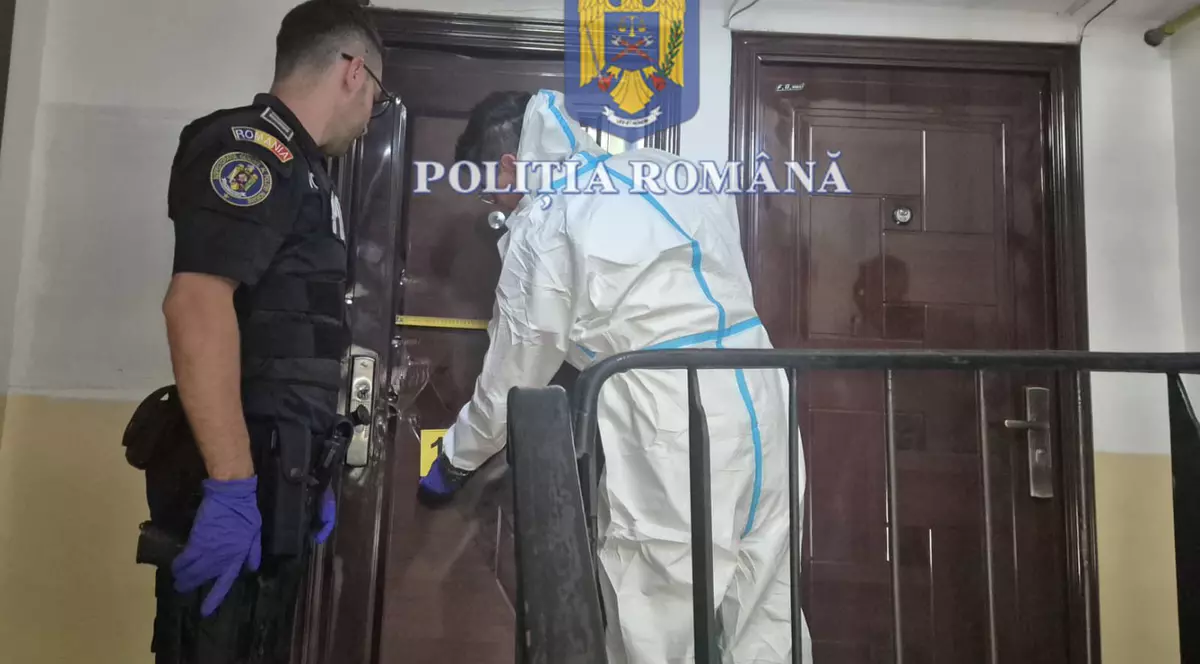 Imagine cu un polițist și un criminalist aflați în fața ușii apartamentului unde a fost ucisă femeia de 44 de ani din Craiova