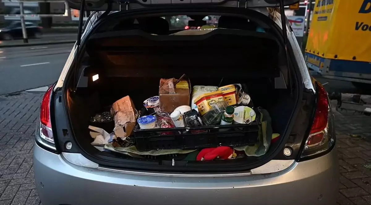 Portbagajul unei mașini gri este plin cu produse lactate, luate de șofer după ce un TIR încărcat cu alimente s-a răsturnat pe șosea, Olanda, 3 august 2025