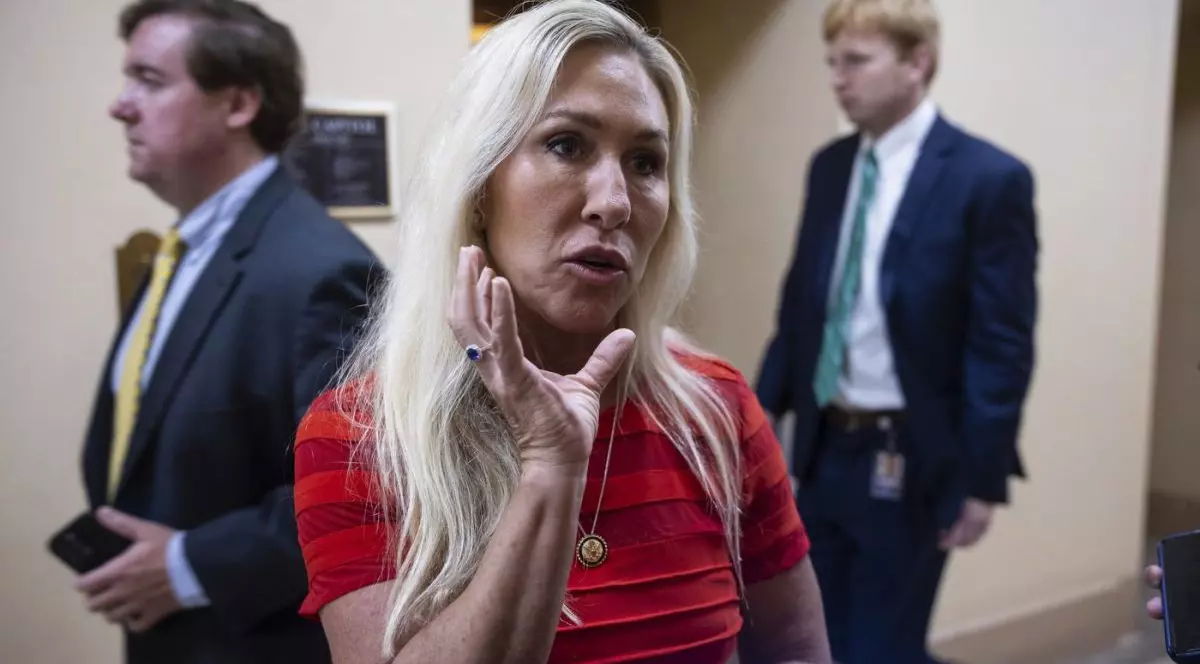 Marjorie Taylor Greene, îmbrăcată într-o rochie roșie, vorbește dă declarații la Capitoliul pe 22 iulie 2025