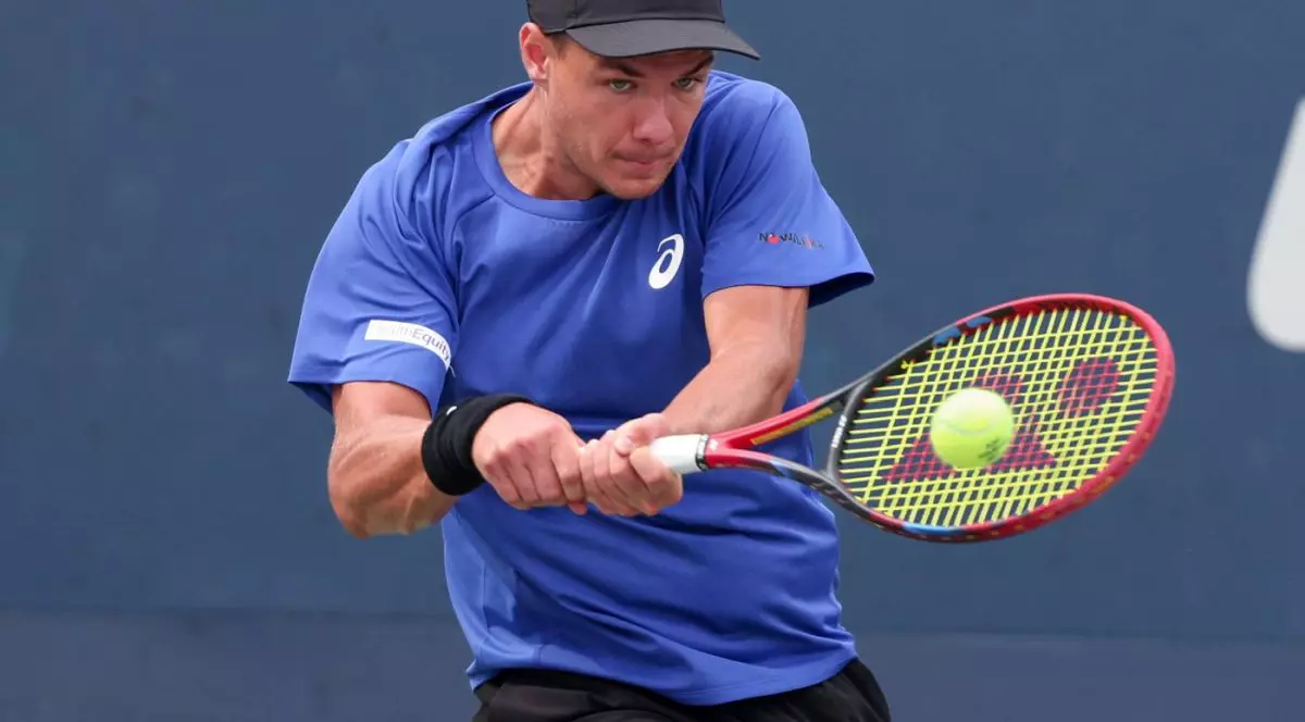 Kamil Majchrzak, cu o șapcă neagră pe cap și în tricou albastru, returnează o minge în timpul unui meci de la US Open, august 2025