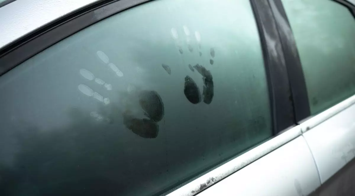 Urme de mâini pe un geam aburit de mașină