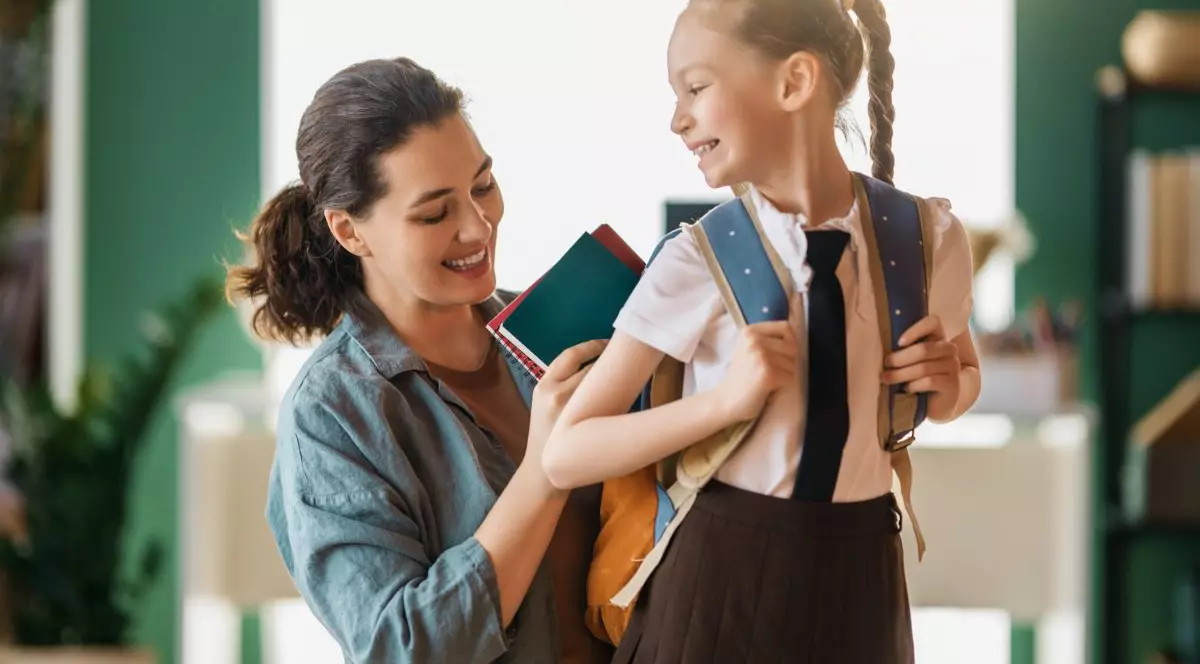 Mamă care își pregătește copilul pentru școală