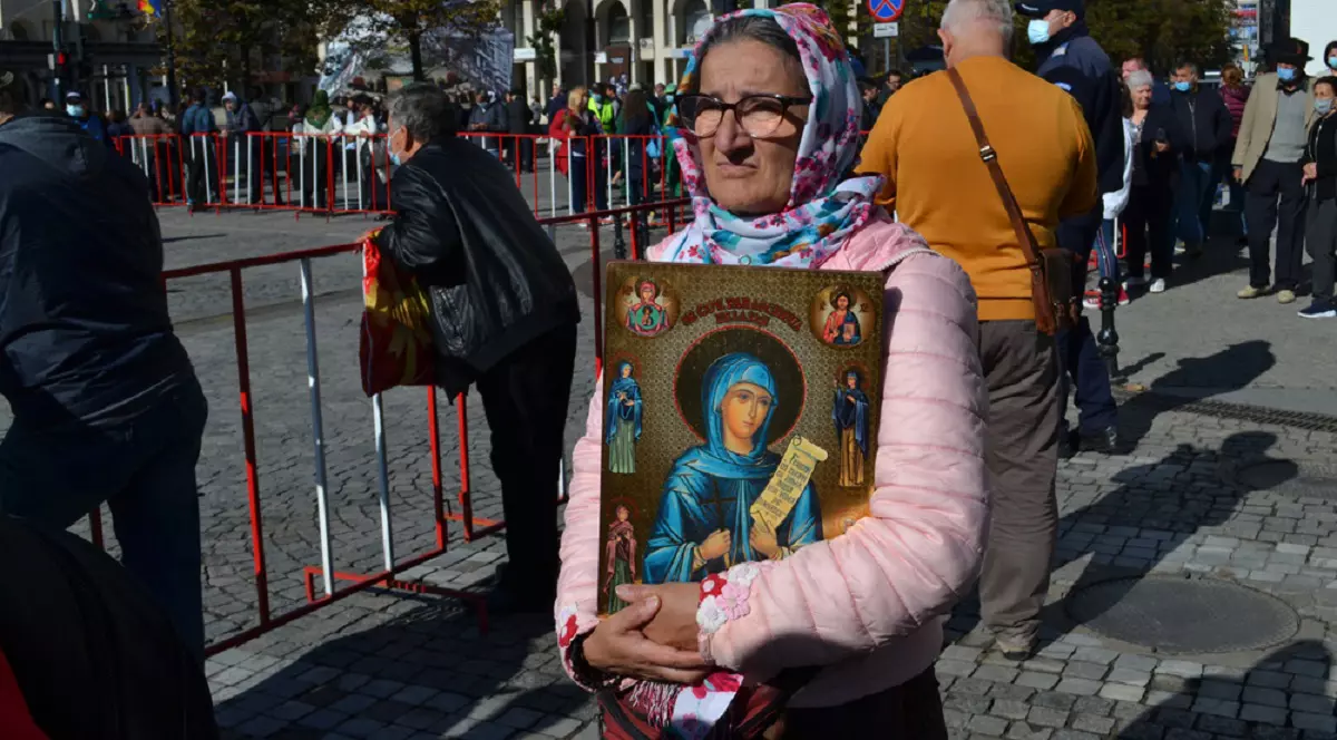 Calendar ortodox octombrie 2025 - Imagine cu o batrana care tine in brate o icoană ce o înfăţişează pe Sf Parascheva, în timpul pelerinajului de la Iaşi