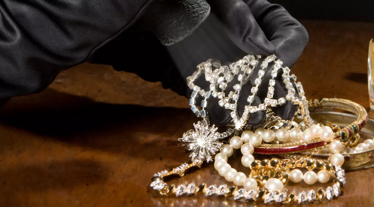 O persoană cu mănuși care analizează mai multe bijuterii