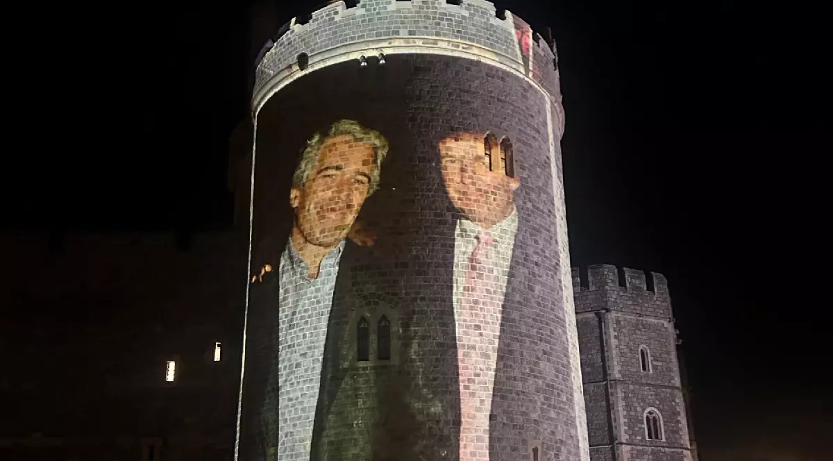 Imaginea prezintă un turn de piatră, al castelului Windsor, pe care este proiectată o fotografie a două persoane. Scena se petrece noaptea. Unul dintre bărbați, cel din dreapta, este Donald Trump, iar celălalt bărbat, aflat în stânga, este zâmbitor. Împrejurimile sunt foarte întunecate, iar în prim-plan se pot distinge câteva siluete de persoane care privesc proiecția.