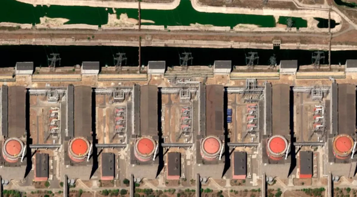 Imagine din satelit a centralei nucleare din Zaporijia, care prezintă cu sfere roșii cele șase unități ale reactorului și canalul de admisie a apei de răcire, 12 august 2025.