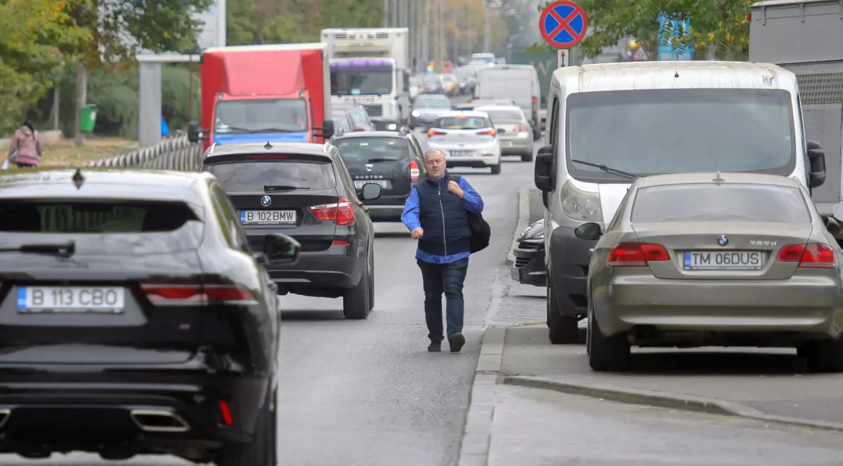 Un barbat merge pe carosabil in Bucuresti