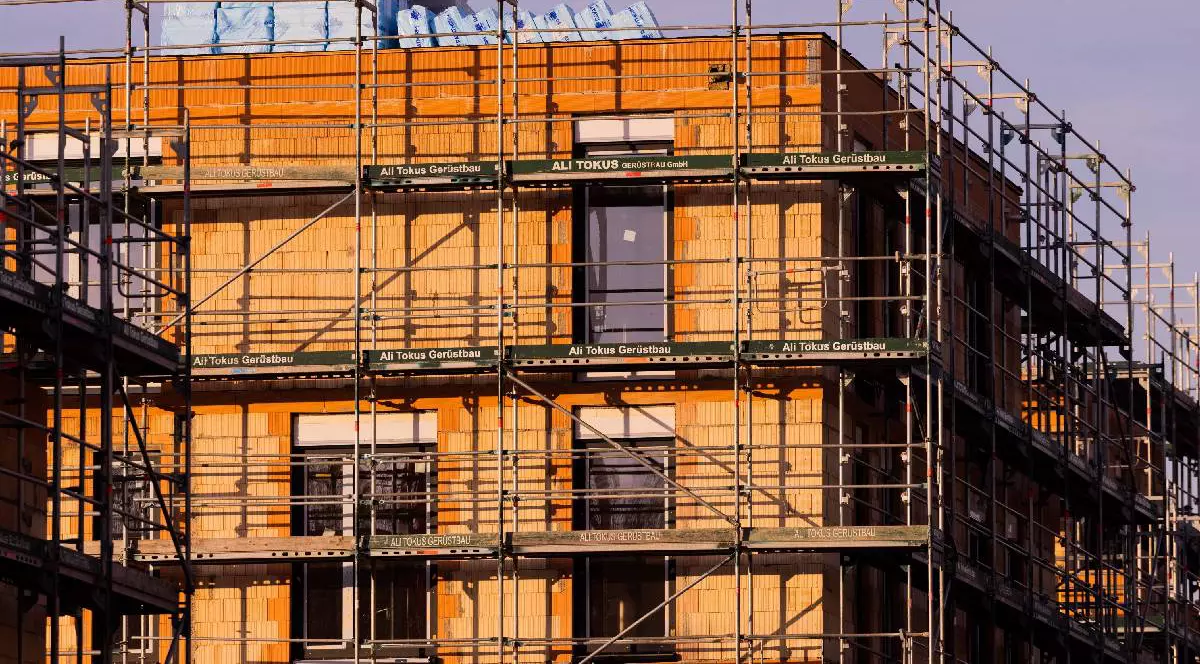 O clădire de locuințe noi în construcție strălucește în lumina soarelui cald