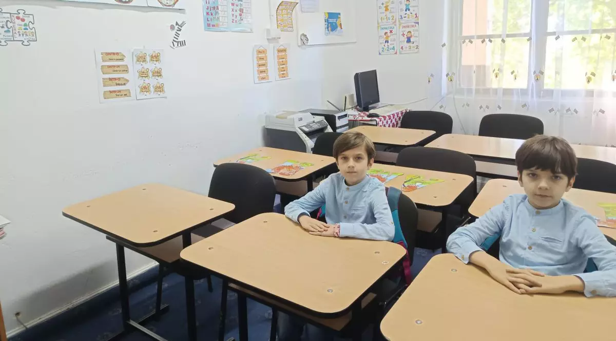 Elevi în bănci într-o clasă goală