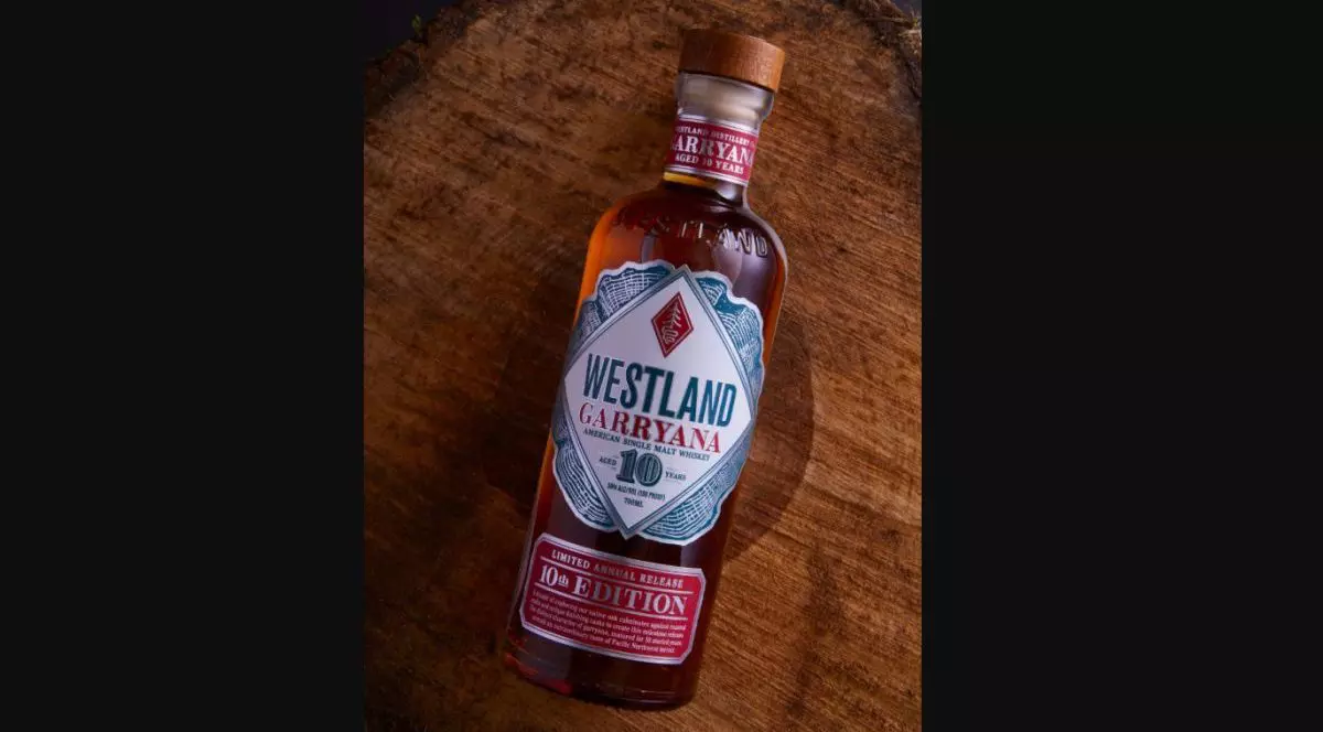 O sticlă de whiskey Westland Garryana stă culcată pe o masă maro de lemn