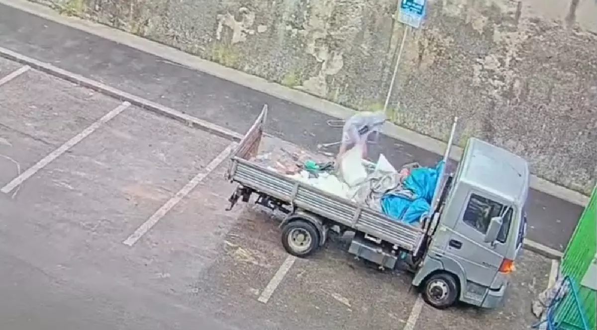 Doi bărbați aruncă molozul dintr-o camionetă, pe o stradă din Cluj