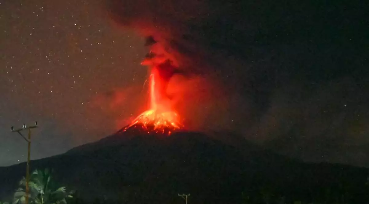 Momentul în care vulcanul Lewotobi Laki-Laki erupe în Indonezia, se vede cum lava fierbinte și roșie începe să curgă de jur împrejurul craterului, iar un jet de lava roșie și fum este aruncat în aer