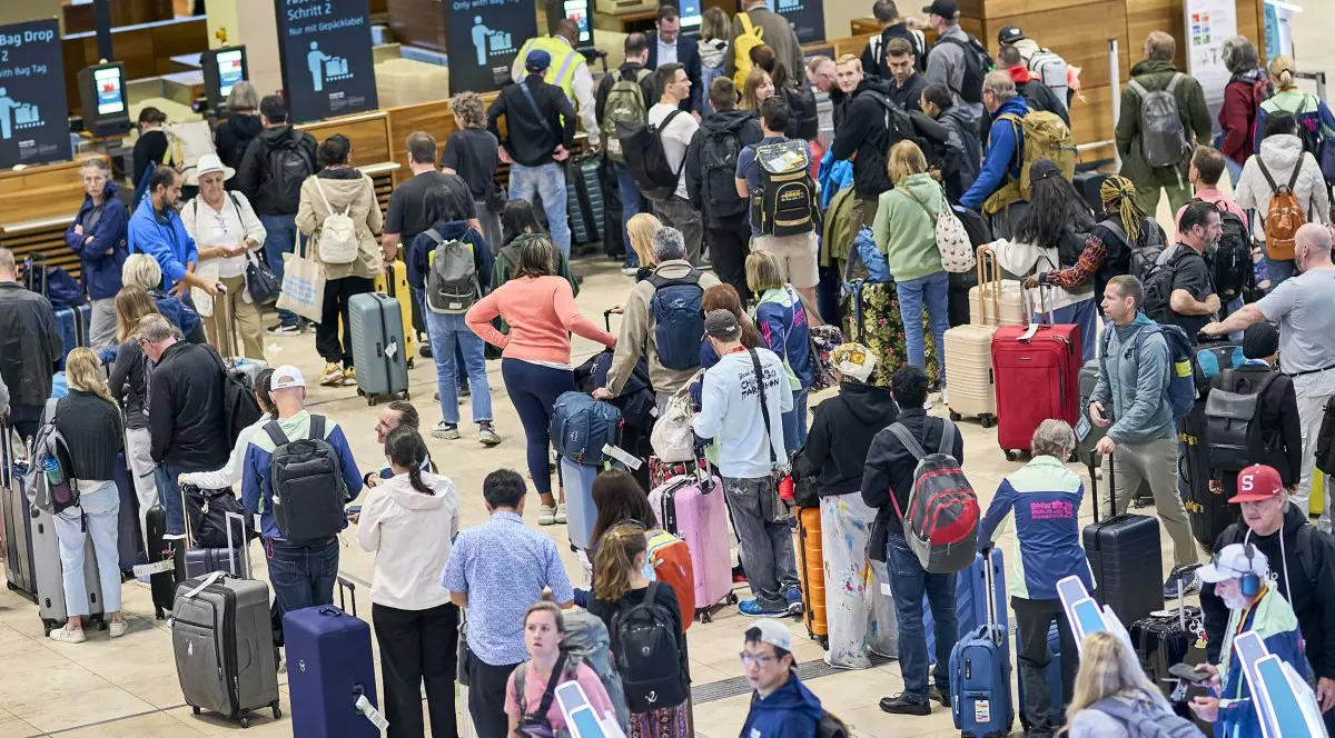 Pasagerii stau și așteaptă în fața ghișeelor ​​de check-in din Terminalul 1 al Aeroportului Berlin Brandenburg, 22 septembrie 2025.