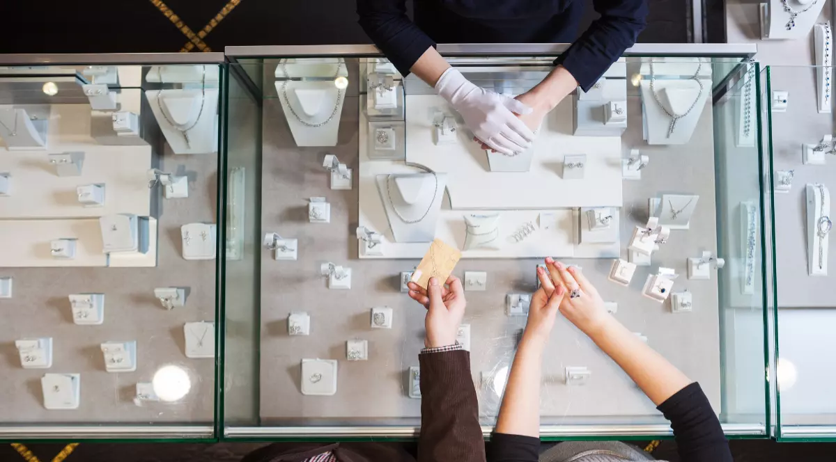 Un magazin de bijuterii în care se află un vânzător și clienți