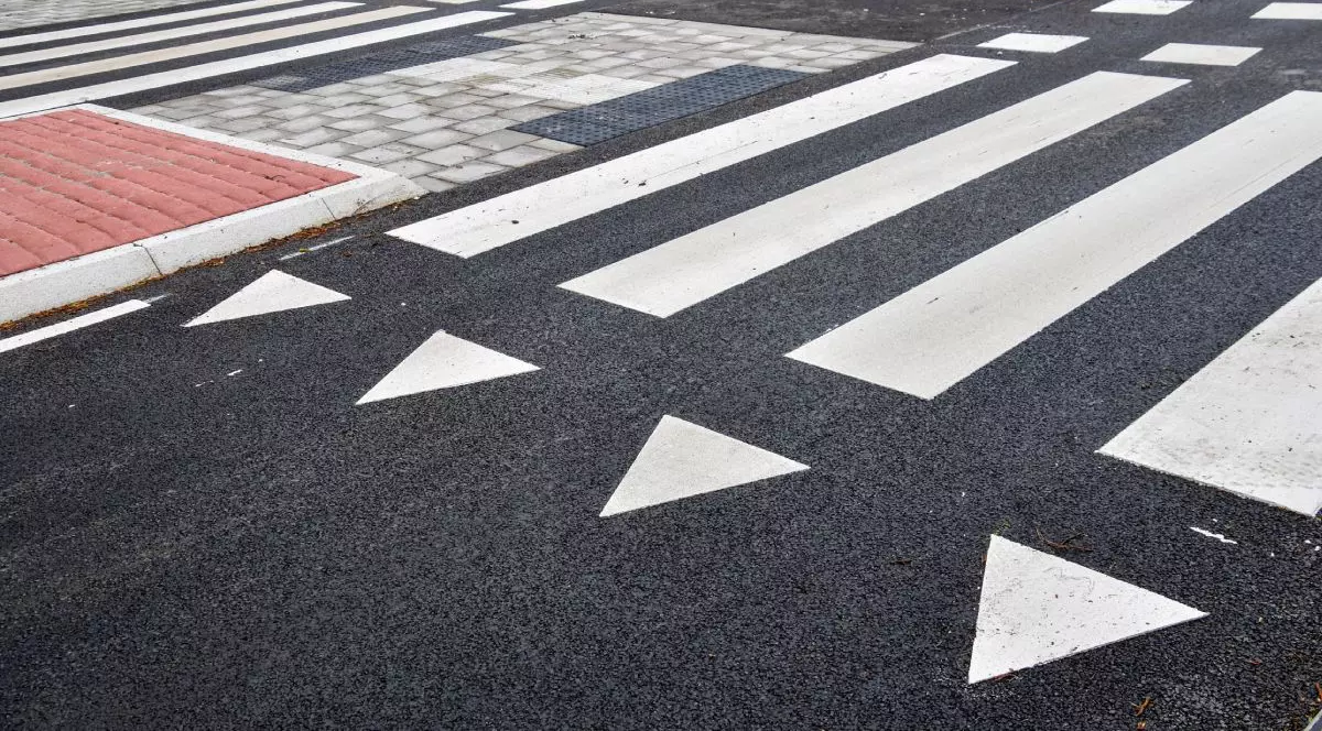 Marcaj tutier alb, sub formă de triunghiuri, cu numele de dinti de rechin , langă un marcaj de trecere de pietoni