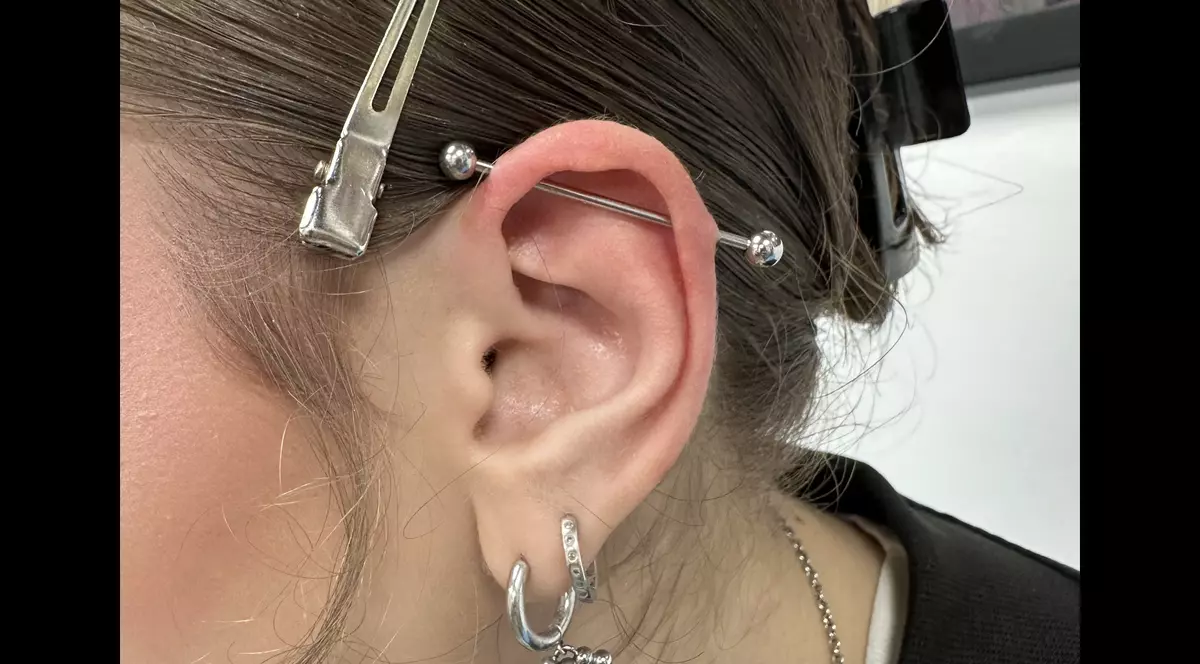 2nd Face Tattoo - poza cu urechea unei fete satene avand un piercing lung in partea superioara si doua piercinguri in partea de jos