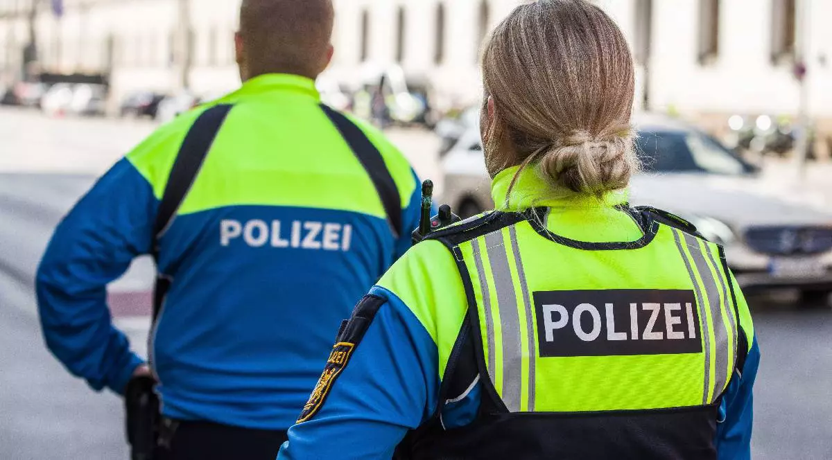 Doi polițiști din Bavaria patrulează pe o stradă îmbrăcați în uniformă