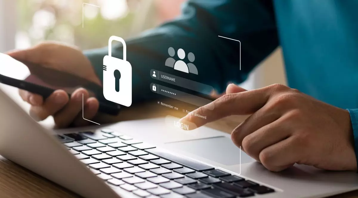 Mâna unui bărbat care este la laptop, iar pe fotografie apare un concept digital de securitate cibernetică și confidențialitate pentru protejarea datelor