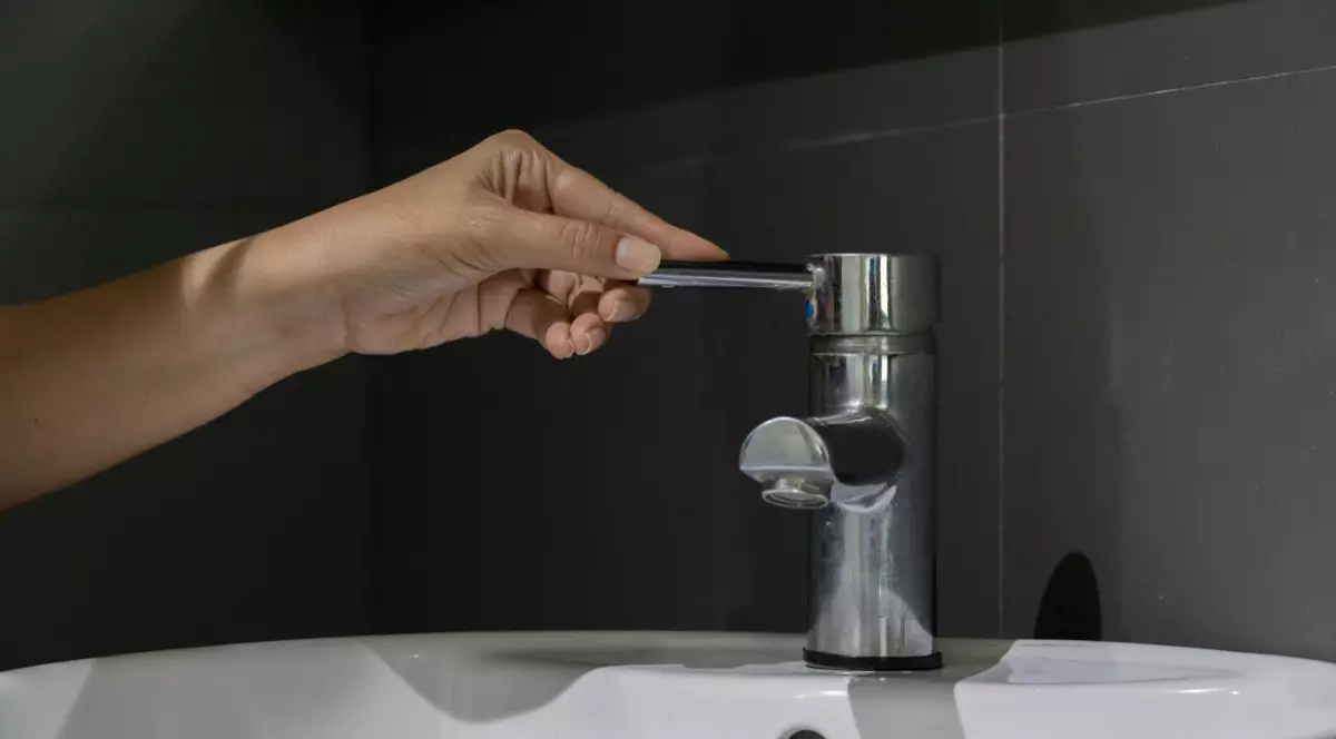 O persoană care deschide un robinet de apă