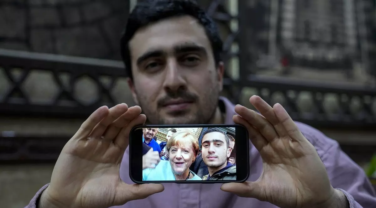Anas Modamani, 27 de ani, refugiat sirian în Germania, arată faimoasa sa selfie cu cancelarul german Angela Merkel, pe care a făcut-o după sosirea sa în țară, într-un restaurant sirian din Berlin, marți, 10 decembrie 2024.