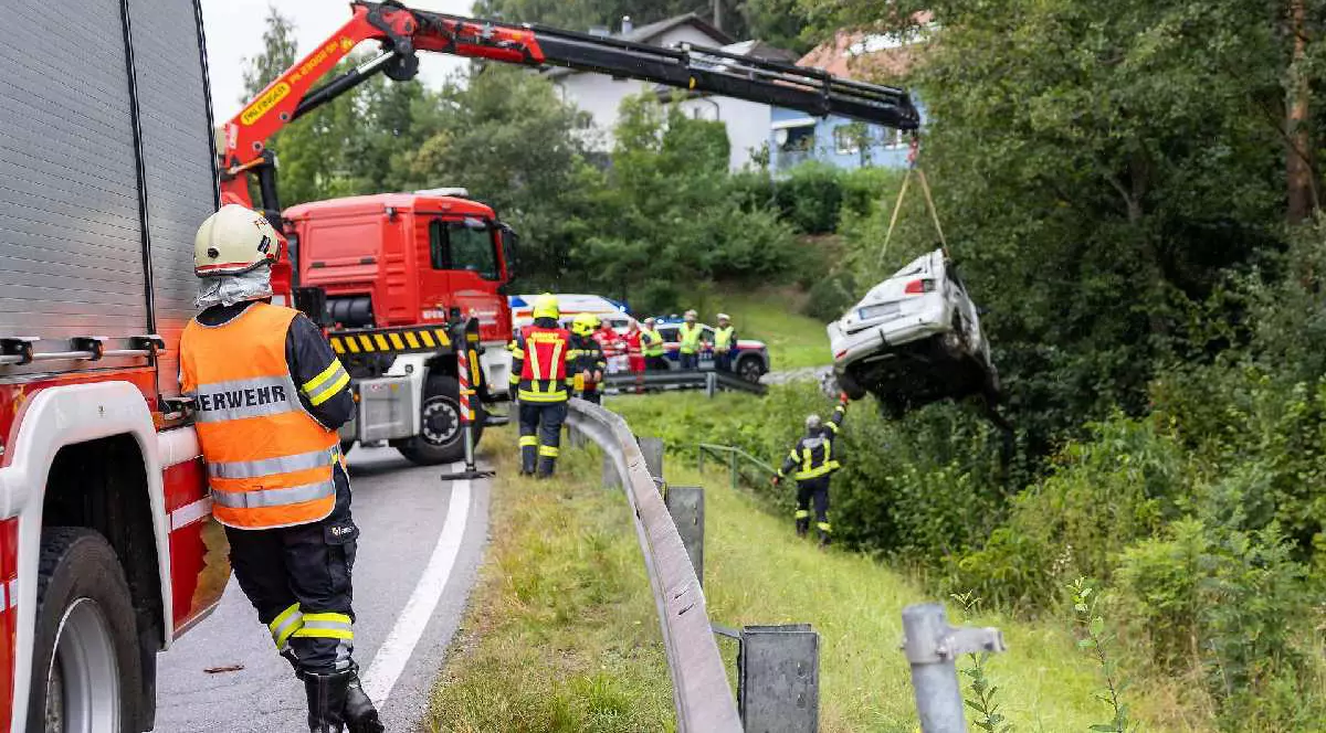 Mașină ridicată din albia unui pârâu, în Austria. Mai mulți pompieri supraveghează acțiunea