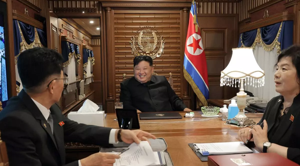 Fotografie furnizată de guvernul nord-coreean cu liderul Kim Jong Un, zambitor, asezat la birou, cu steagul pe peretele din spate, in centru, pleacă din Phenian, ,Coreea de Nord, cu trenul, luni, 1 septembrie 2025, îndreptându-se spre Beijing.