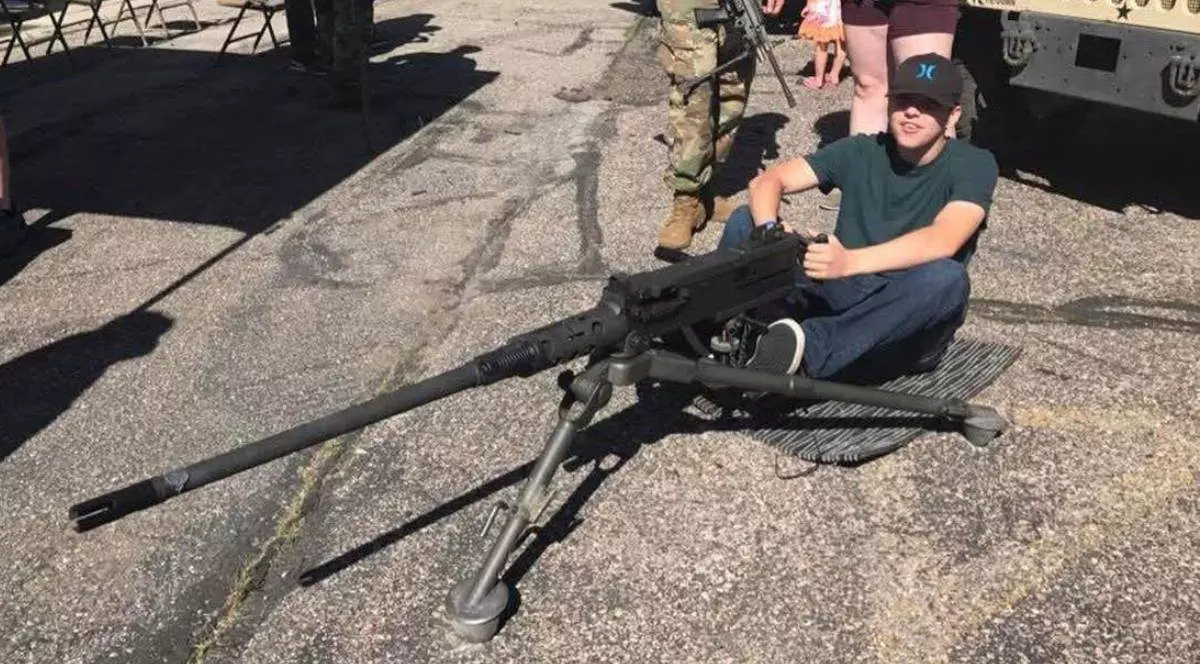 Imagine cu Tyler Robinson stând pe jos și având mâinile pe o armă